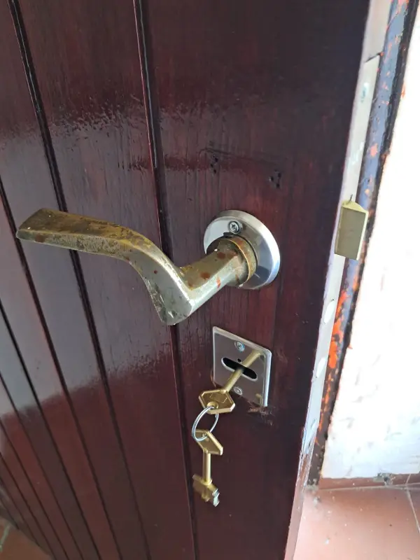 Cerradura de doble paleta instalada en una puerta de madera, con el juego de llaves nuevas puesto