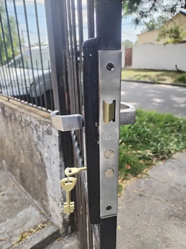 Cerradura nueva instalada en una reja de hierro, con las llaves puestas