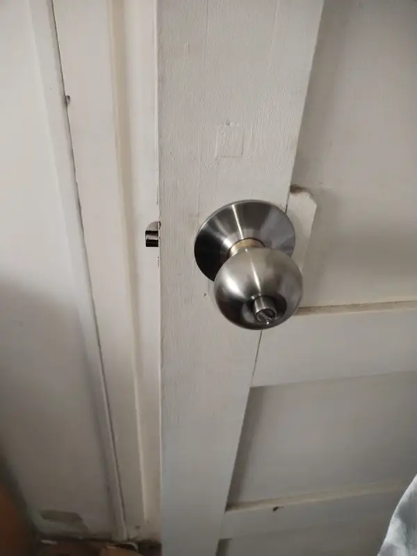 Picaporte con cerradura nuevo colocado en una puerta blanca