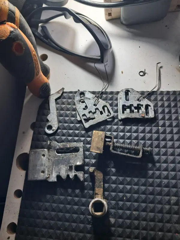 Piezas de una cerradura desarmada sobre la mesa de trabajo, listas para reparar